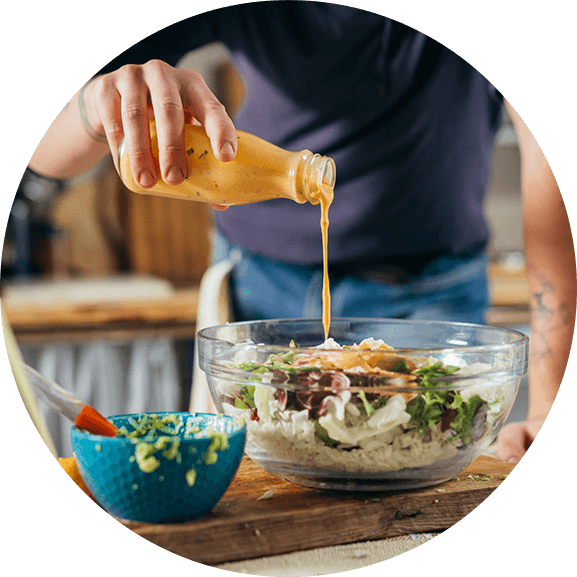 man drizzling ready-to-use salad dressing